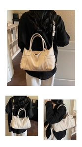 Close-up of beige lychee grain leather tote bag with dual handles and detachable strap