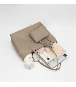 Vue de dessus du grand sac cabas en nylon kaki montrant l'intérieur spacieux avec accessoires