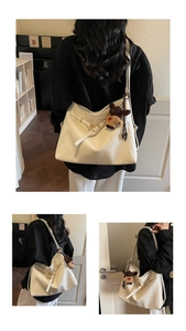 Close-up of cream white tote bag with lychee texture and cute bear charm detail