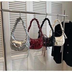 Detail of trendy pleated hobo bags with bows in silver, burgundy, black, and beige colors