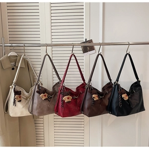 Collection of large tote bags in five colors with cute bear charms hanging on a rack