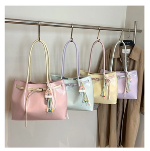 Detail of colorful tote bags with rainbow tassels and buckle hanging on a rack