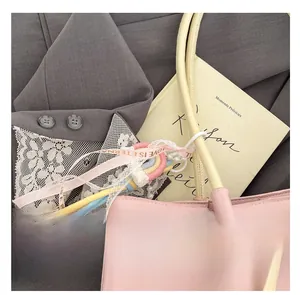 Detail of colorful rainbow charm with pearls and LOVE ribbon on a pink leather tote bag