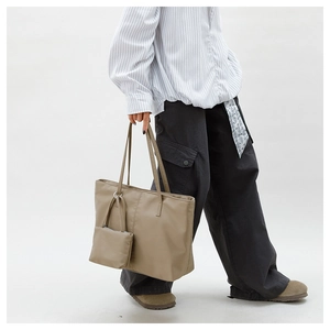 Détail du grand sac cabas en nylon kaki avec pochette assortie porté par le mannequin