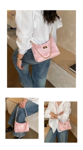 Detailed close-up of pink textured fabric bag with golden chain and metal turn-lock