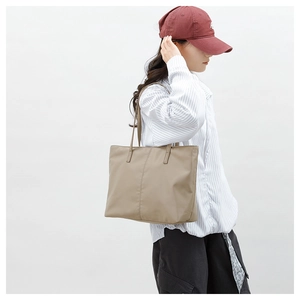 Vue latérale d'un sac cabas en nylon kaki porté à l'épaule pour un look quotidien décontracté