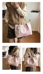 Detailed view of pink leather tote bag with rainbow Love Letter charm and shoulder strap