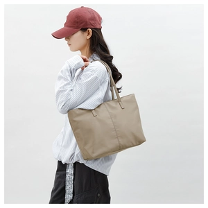 Gros plan d'un sac cabas minimaliste en nylon kaki avec coutures et fines lanières