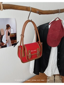Detail view of vintage red and brown messenger bag with retro metallic buckles