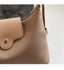 Close-up of khaki tote bag showing twill fabric texture and smooth leather flap details