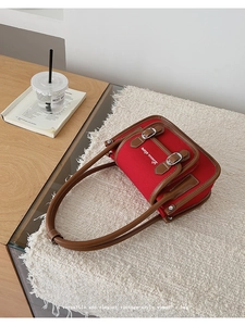Close-up of vintage red canvas tote with leather trim and Liunuu store embroidery