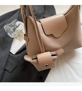 Detail of light brown tote bag with twill texture and matching mini coin purse attachment