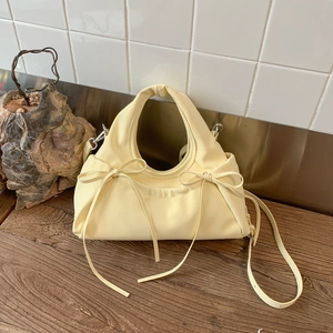 Detailed view of cream bow-knot pleated cloud bag with soft synthetic leather texture