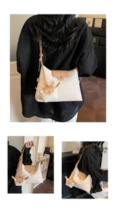 Detail view of cream tote bag with tan leather strap and matching mini coin purse set