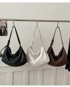 Detail view of large faux leather tote bags with knotted straps in three chic colors