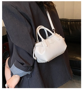 Detail of white lychee leather tote bag with round handles and adjustable strap
