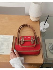 Detailed top view of red canvas square handbag with brown leather trim and embroidery