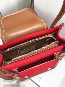 Detail view of double zipper compartments in canvas and leather handbag with silver hardware