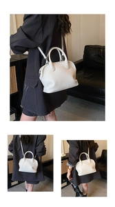 Detailed macro view of the white lychee grain leather handbag with dual round handles