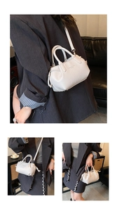 Detail of cream leather mini square bag featuring side drawstring and detachable strap