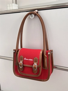 Detail of red canvas bag featuring Linuu-store embroidery and brown leather trim
