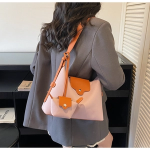 Detail van roze en oranje lederen draagtas met bijpassende mini-portemonnee en riem