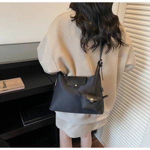 Detail of black minimalist tote set with mini charm pouch on casual shoulder bag
