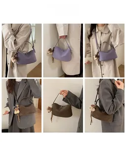 Dettaglio borsa a mezzaluna con ciondolo a forma di orsetto e chiusura a girello