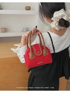 Detailed view of red canvas mini handbag with leather trim and gold LIUUU logo