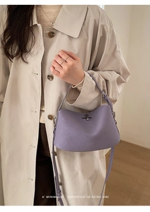 Dettaglio della borsa hobo in pelle viola con chiusura a rotazione scura e logo impresso