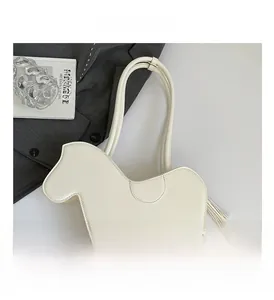 Close-up of cream PU leather horse-shaped bag with stitching and tassel details
