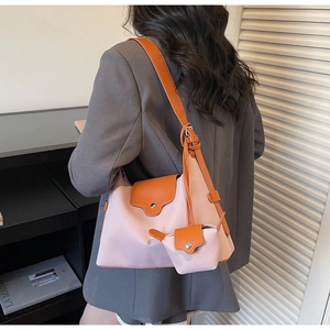 Detail of pink and orange crossbody hobo bag with a matching mini charm pouch on a model