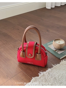 Retro red canvas handbag with leather handles on a wooden floor in an elegant home setting