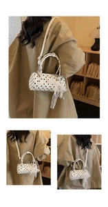 Detailed view of polka dot cylindrical bag with lace bow and pearl pendant details