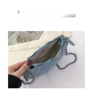 Detalle del interior del bolso medialuna de mezclilla acolchada azul con cadena de plata