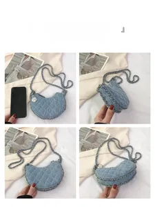 Bolso medialuna de mezclilla azul acolchada con colgante de rosa y detalles de cadena plata