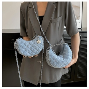 Detalle del bolso hobo de mezclilla azul claro con acolchado de rombos y cadena floral