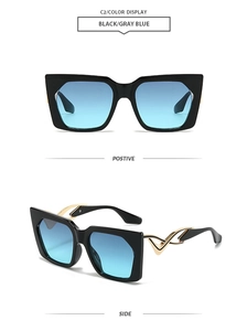 Detail of square oversized sunglasses with blue-grey gradient lenses and gold curved temples