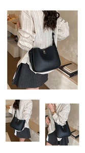 Detail of black lychee grain leather bucket bag with metal buckle and adjustable strap