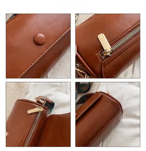 Detail view of brown cylinder bag with gold hardware and vintage pattern strap