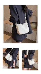 Detail of off-white lychee grain leather crossbody bag with silver metal clasp closure