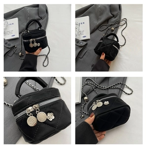 Détail du mini sac seau matelassé noir avec breloques fleurs et bandoulière chaîne