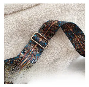 Close-up of adjustable bohemian strap with gold buckle on brown leather bag