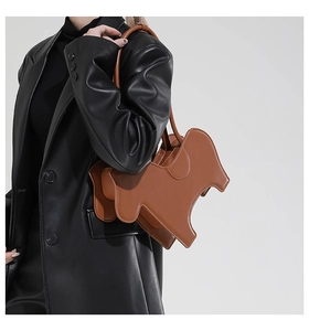 Brown animal shaped leather shoulder bag shown on model with glossy black coat