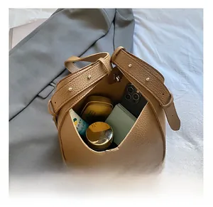 Top view of brown leather bucket bag showing spacious interior with daily essentials