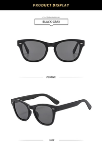 Detail of vintage black frames with silver rivet studs and gray lenses in side view