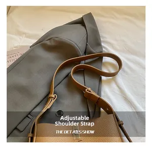 Close-up of brown litchi pattern leather bucket bag with metal lock and adjustable strap