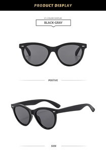 Macro detail of black cat eye sunglasses showing silver stud accents and dark gray lenses