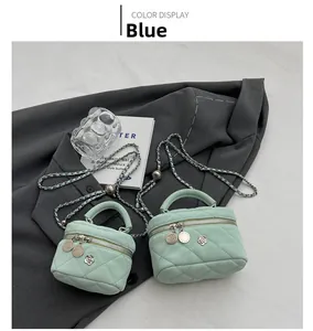 Detail of quilted mini bags in light blue and mint green with flower charms on a blazer
