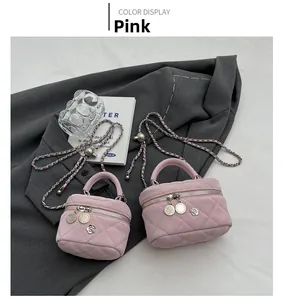Detail of pink quilted mini bag with floral pendant and silver chain on a blazer